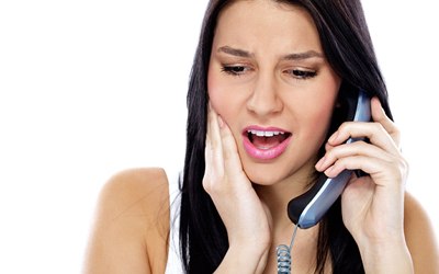 woman with toothache calling dentist