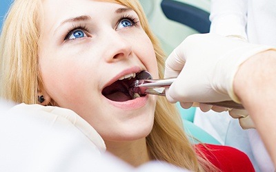 Woman having tooth extracted