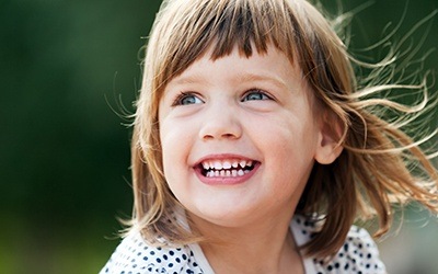 Little girl laughing outdoors