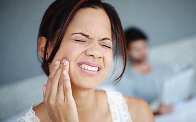 Woman in pain holding her cheek