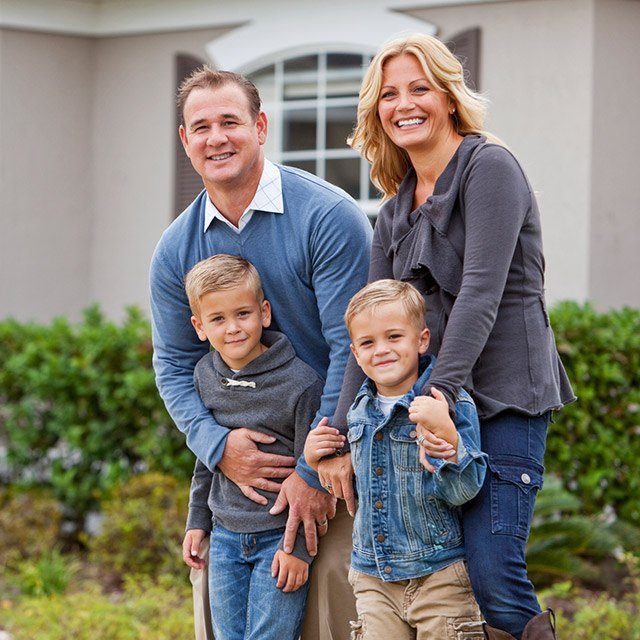 Happy family of four smiling outdoors