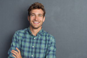 man smiling in front of gray background